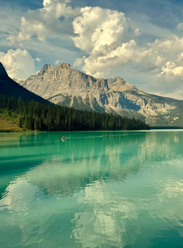 Turquoise mountain lake surrounded by forest and peaks in the Canadian Rockies